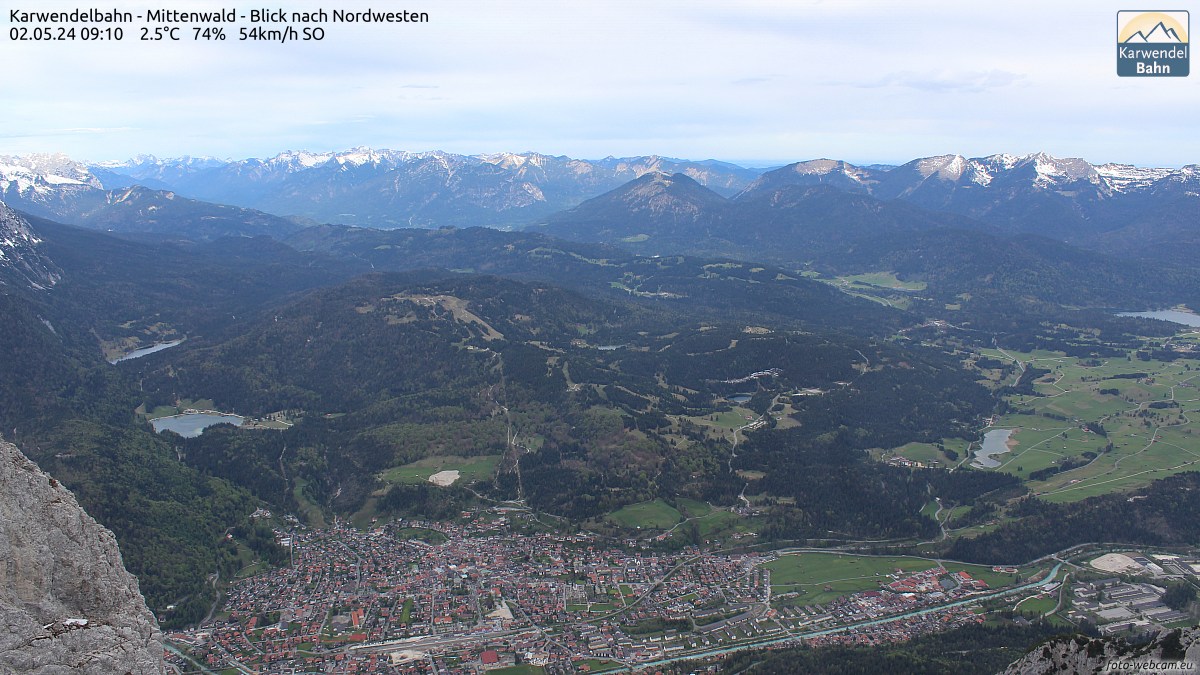 Im Bild sind links die nördlichen Ausläufer des Wetterstein, bis zur Mitte die Ammergauer Alpen und rechts ist das Estergebirge zu erkennen. Im Vordergrund liegt der Markt Mittenwald mit dem Kranzberg sowie links Ferchensee und Lautersee, rechts ist vor dem Estergebirge der Barmsee.